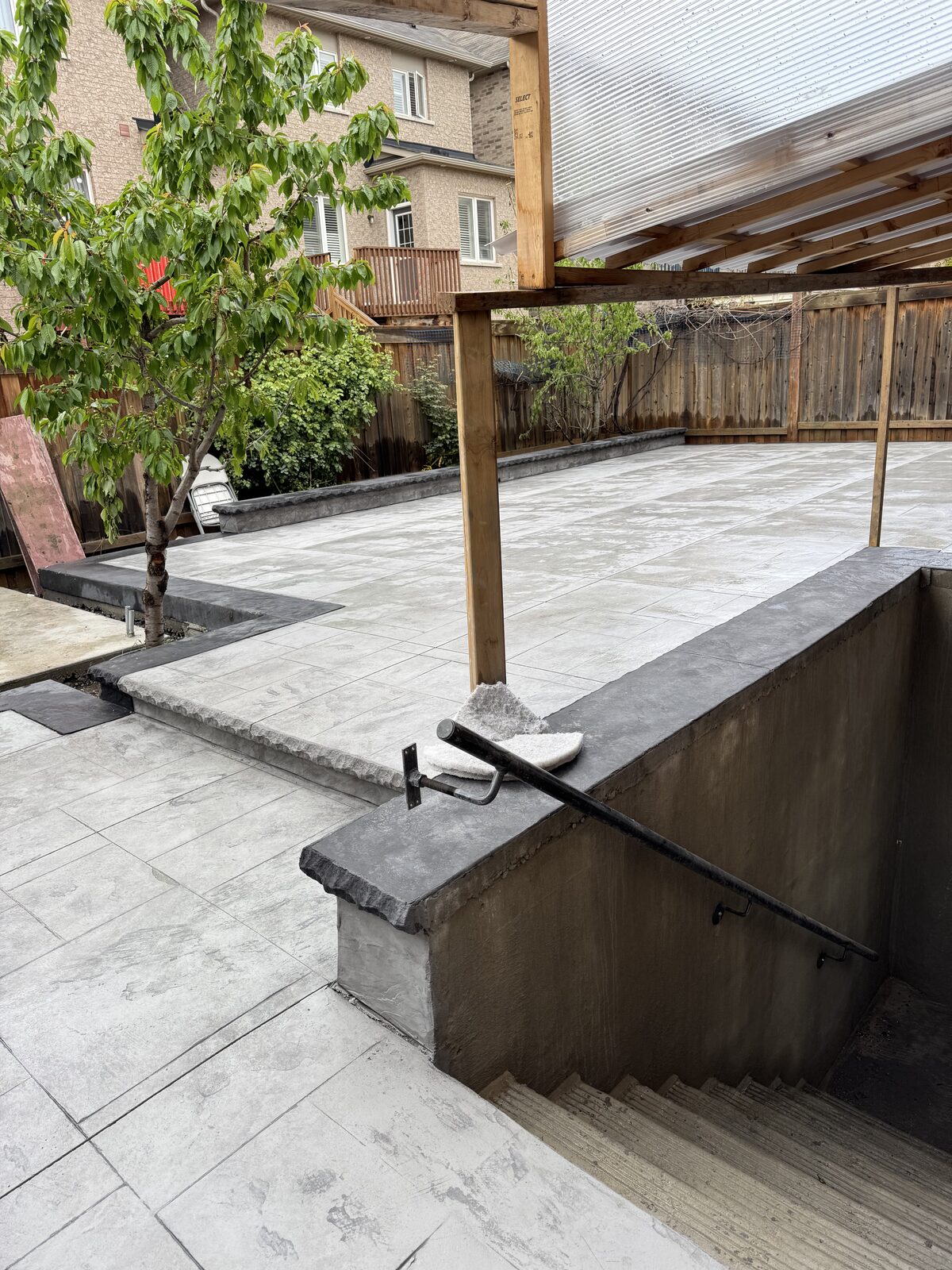 Newly poured concrete patio with stamped stone pattern and retaining walls