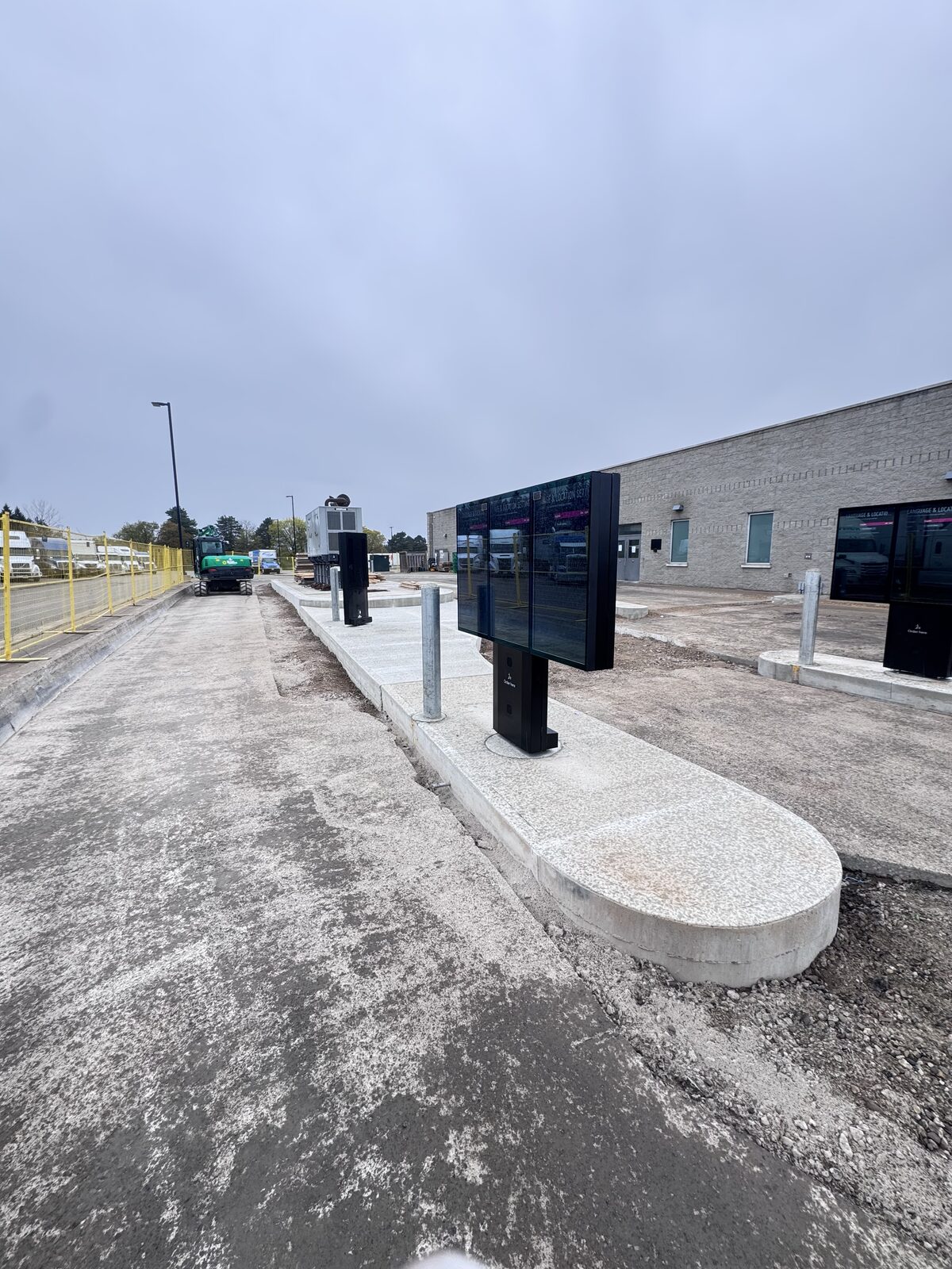 Newly poured concrete area with digital displays and construction equipment