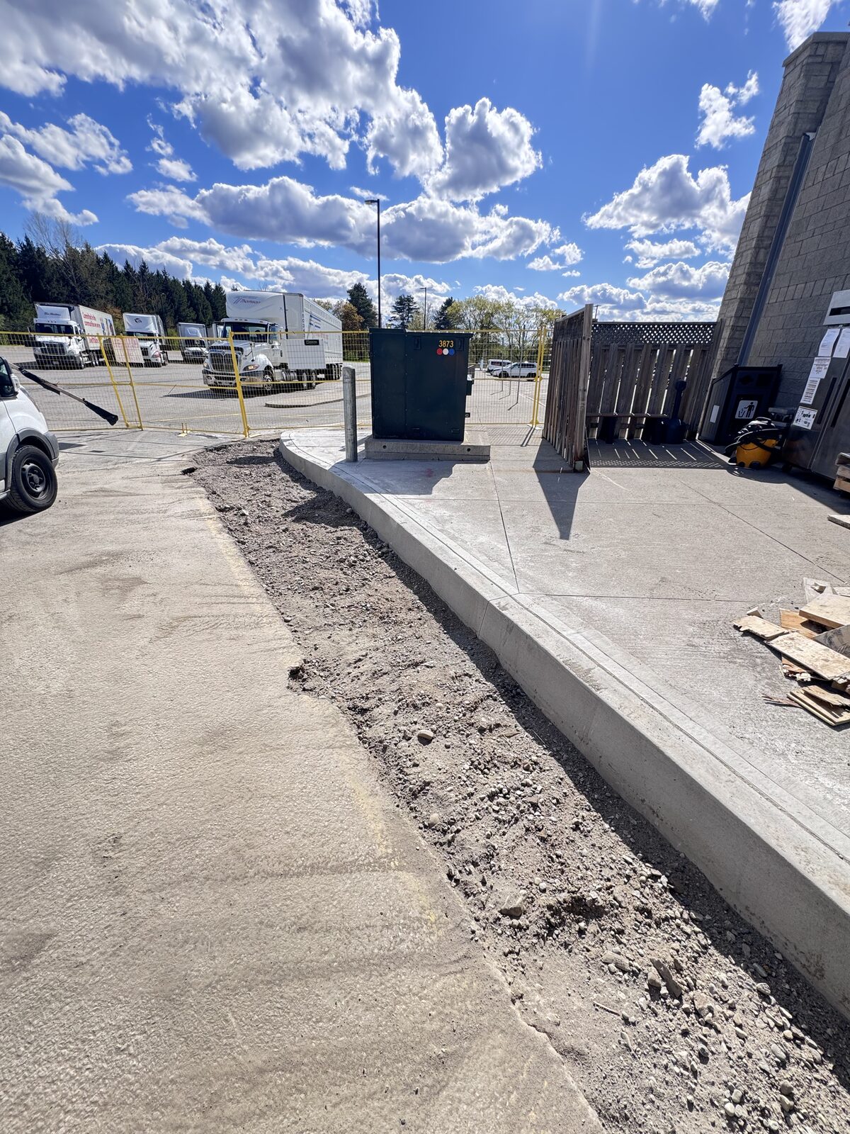 Freshly poured concrete curb and walkway with gravel edge