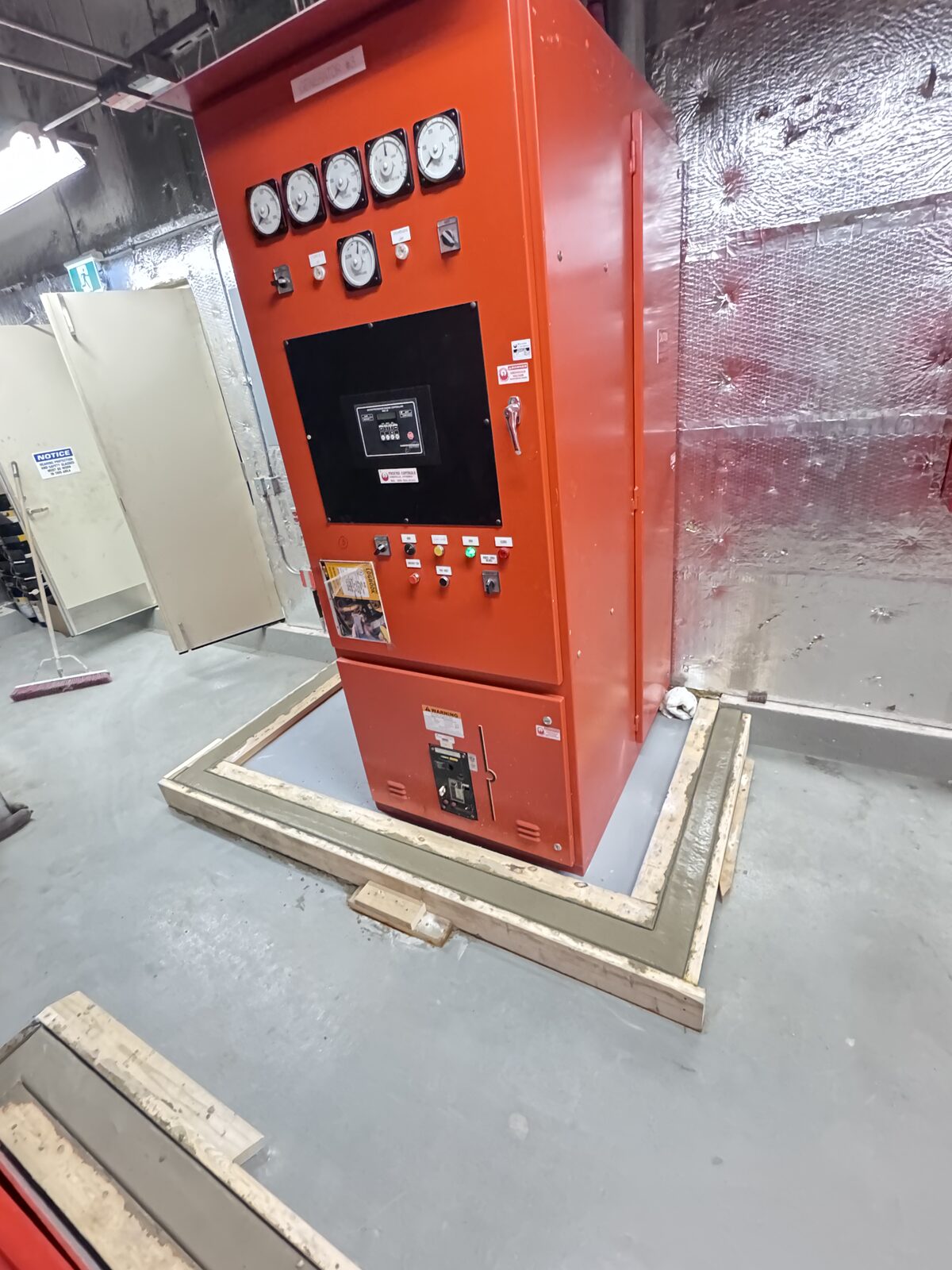 Concrete base poured for electrical equipment cabinet in industrial building.