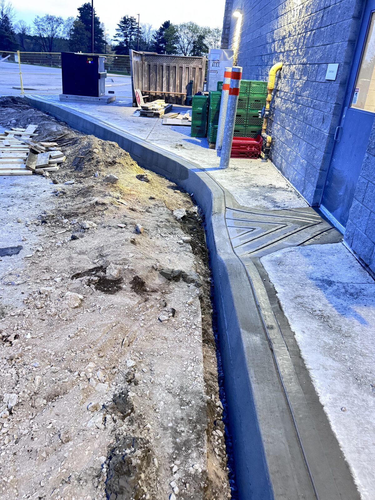 Freshly poured concrete curb and decorative drainage system