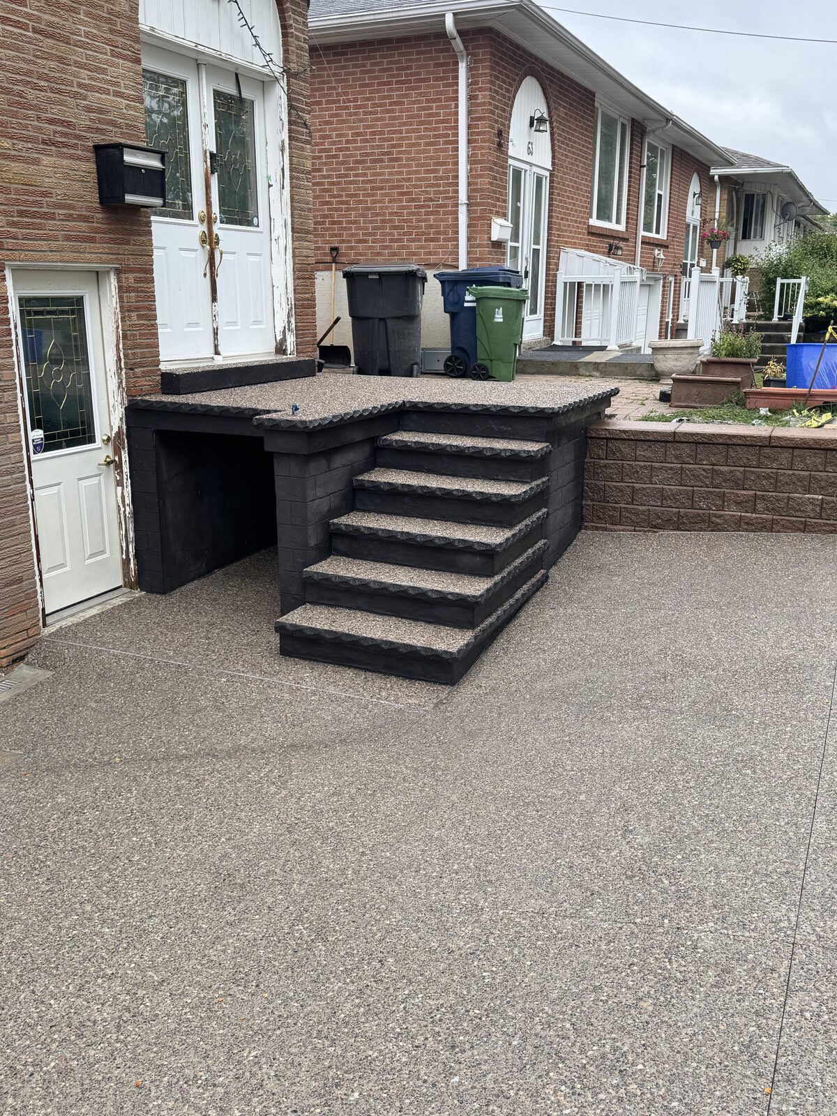 Exposed aggregate concrete stairs and landing with dark contrasting base