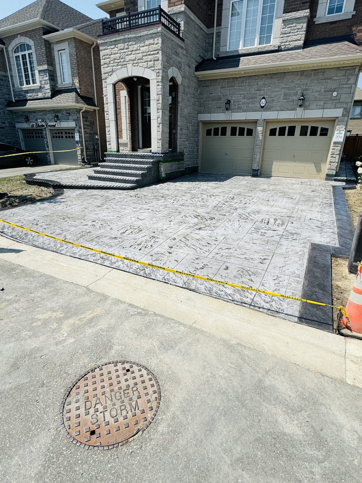 Stamped concrete driveway with concrete steps leading to house