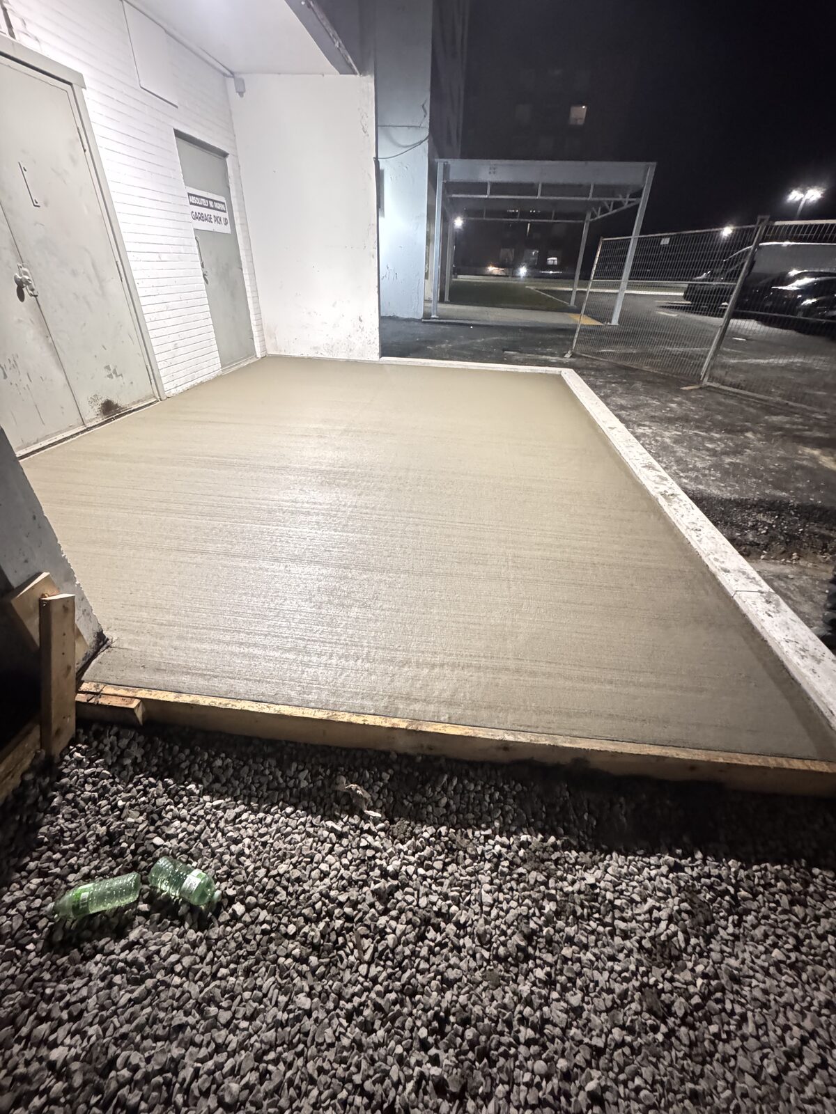 Freshly poured concrete foundation at a commercial building site at night.