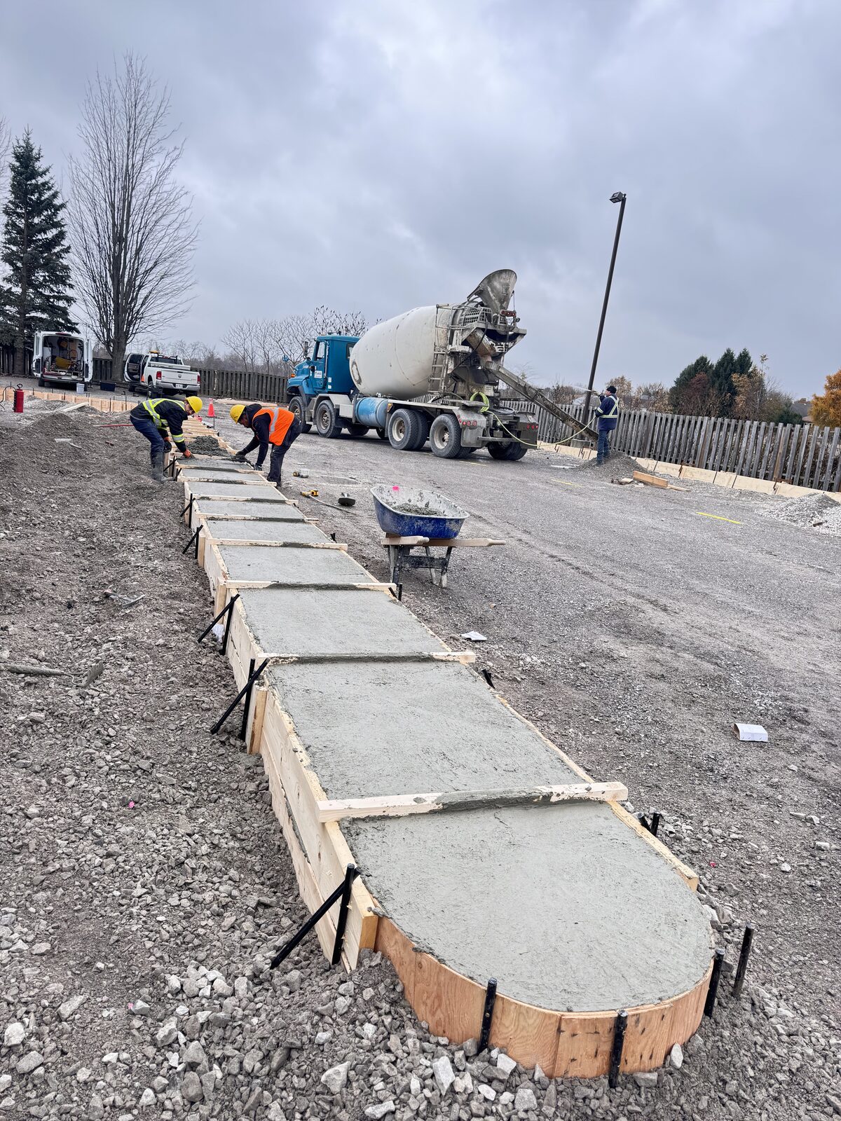 Crew pouring concrete for a new walkway with custom curved forms.