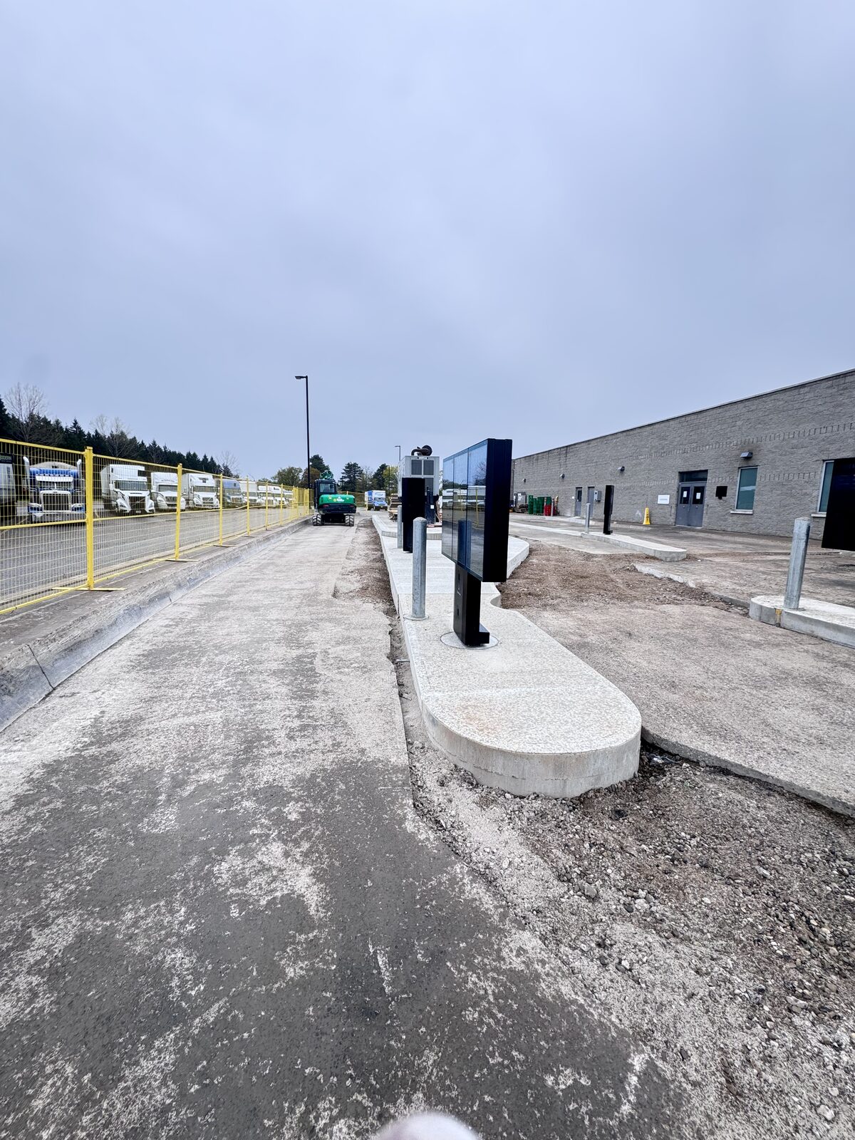 New concrete construction at an industrial facility with truck staging area.