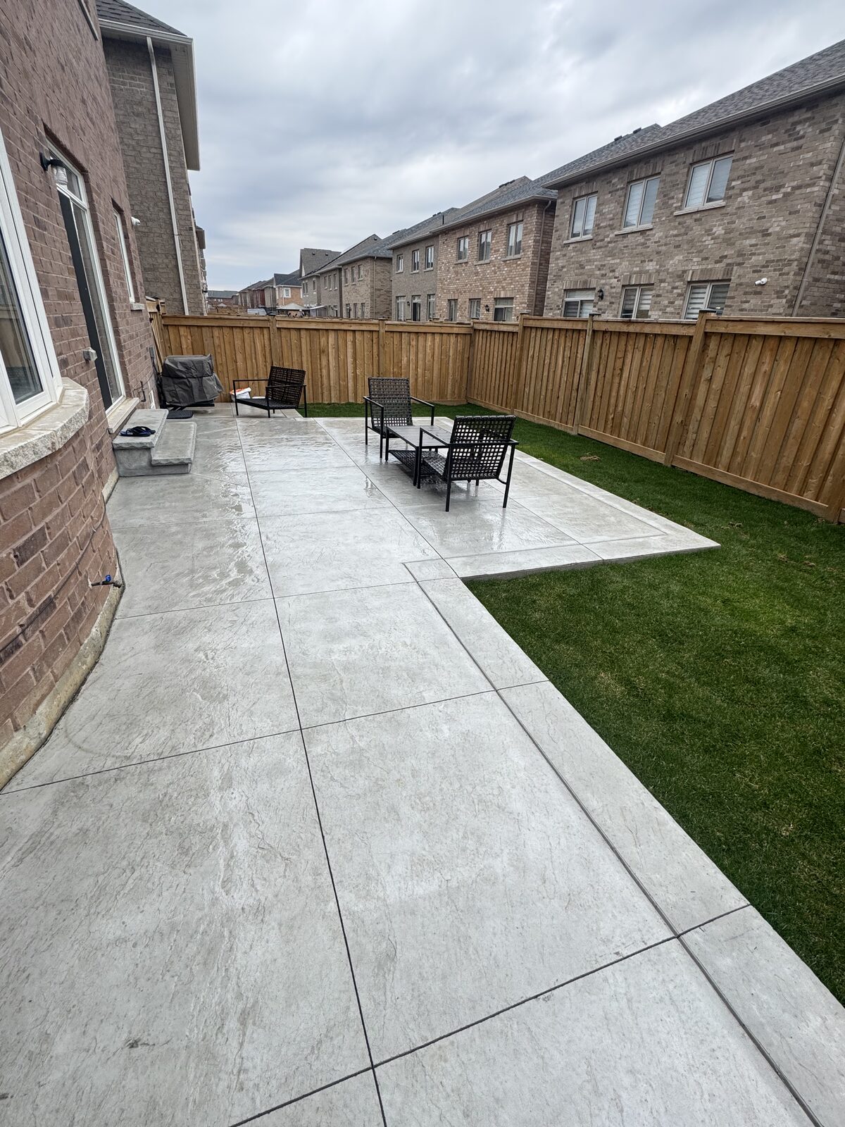 Stamped concrete patio with seating area in a residential backyard