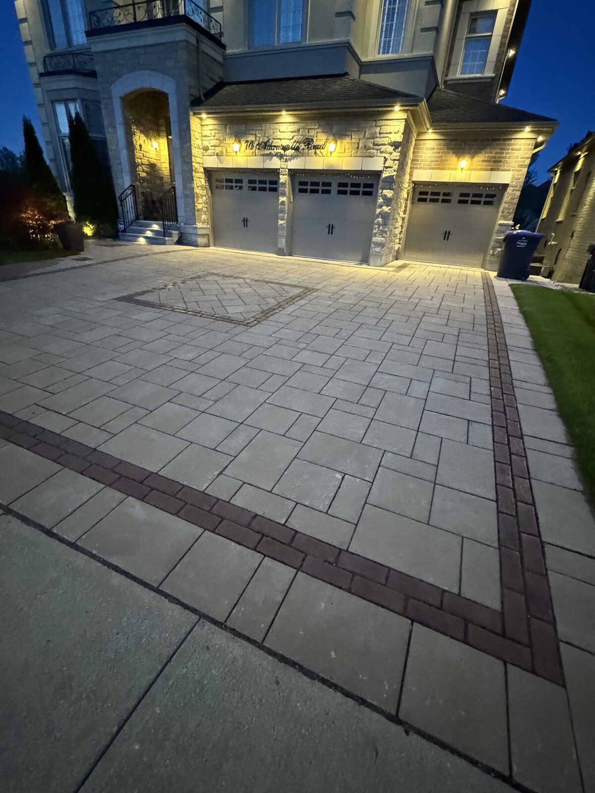 Custom driveway with brick border and inlay in front of luxury home