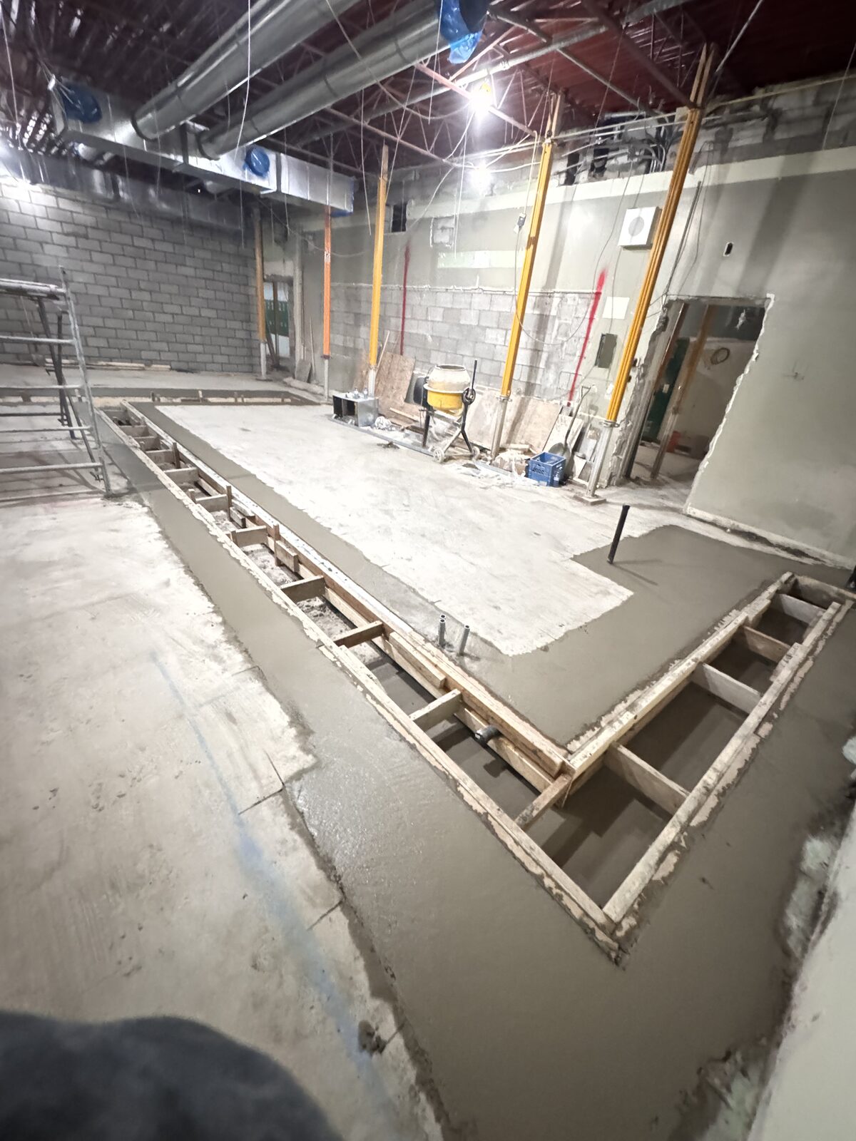 Freshly poured concrete foundation with wooden forms for a commercial building.
