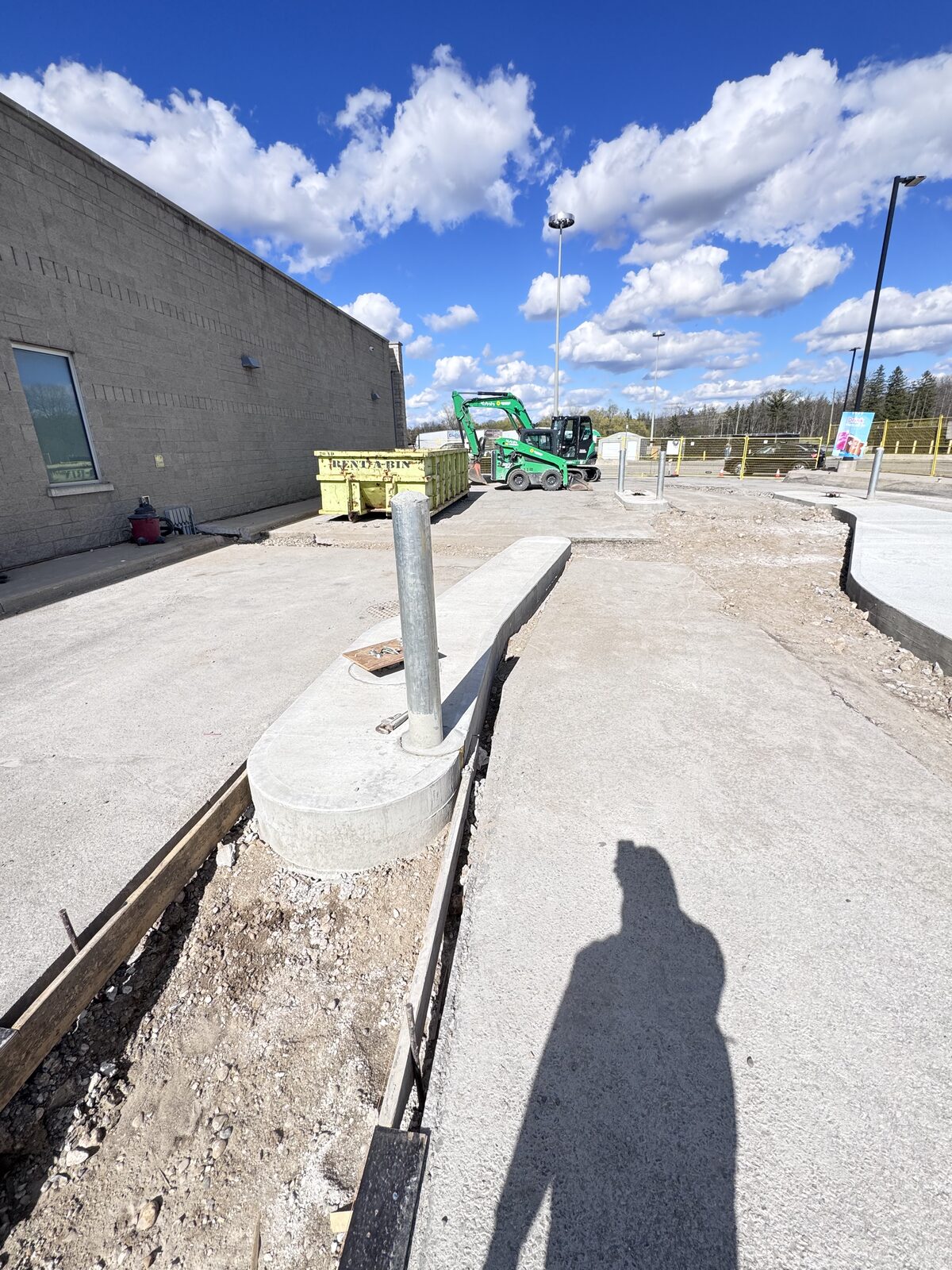 Concrete construction for commercial property with excavator and dumpster
