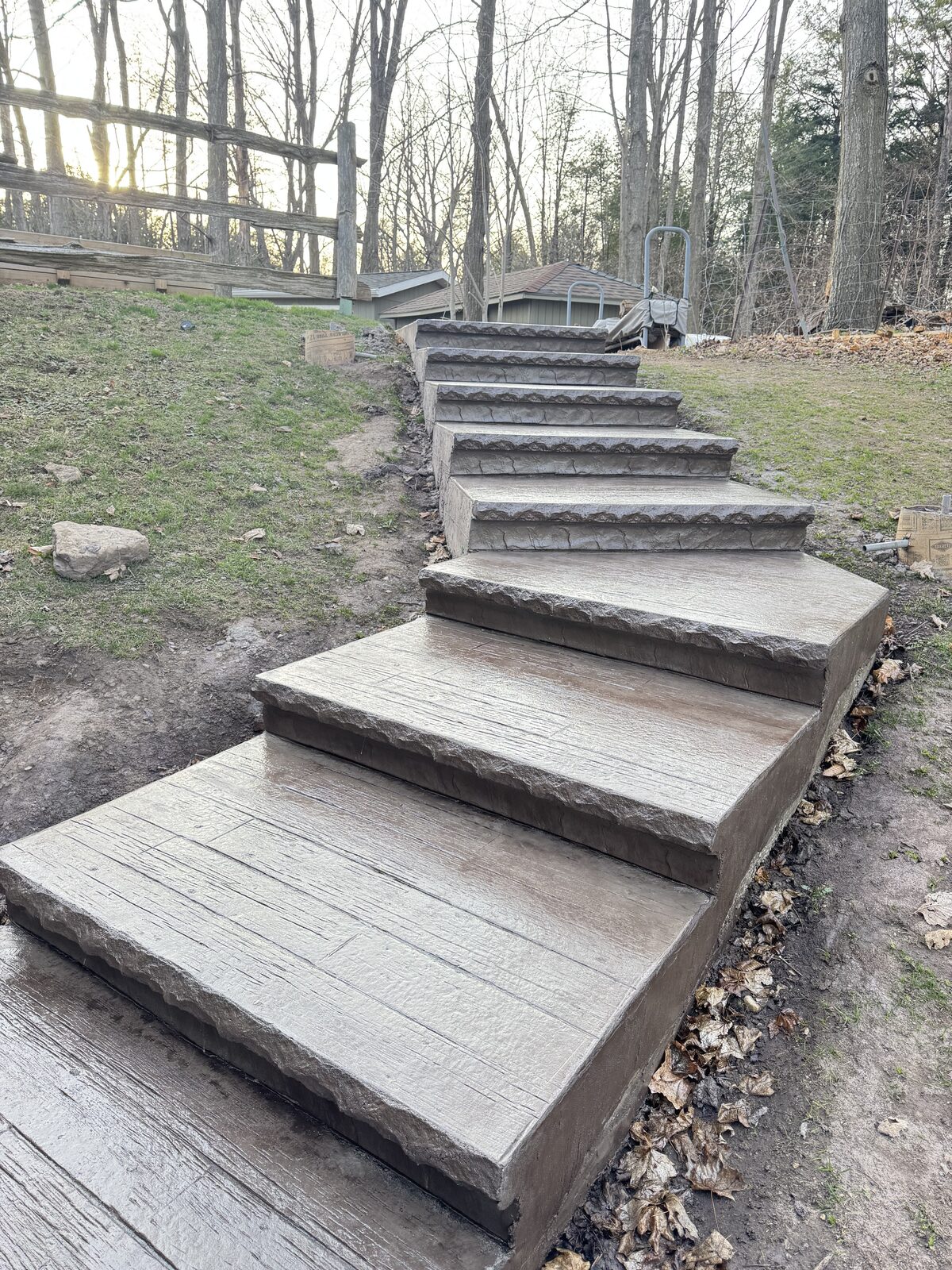 Newly poured concrete stairs with wood grain and stone stamped edges.