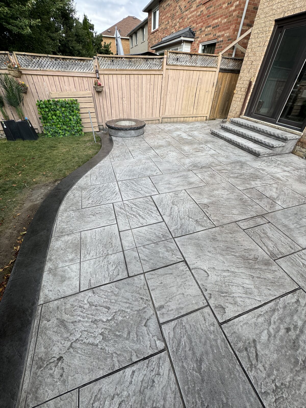 Stamped concrete patio with dark border and stone-like pattern.