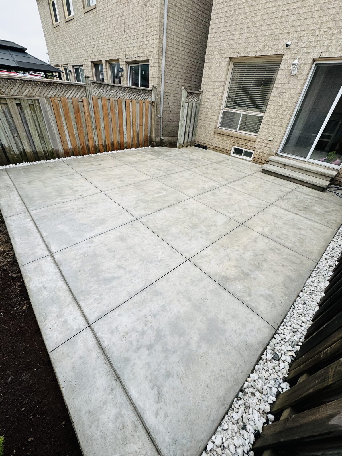 Newly poured concrete patio with expansion joints creating large square sections.