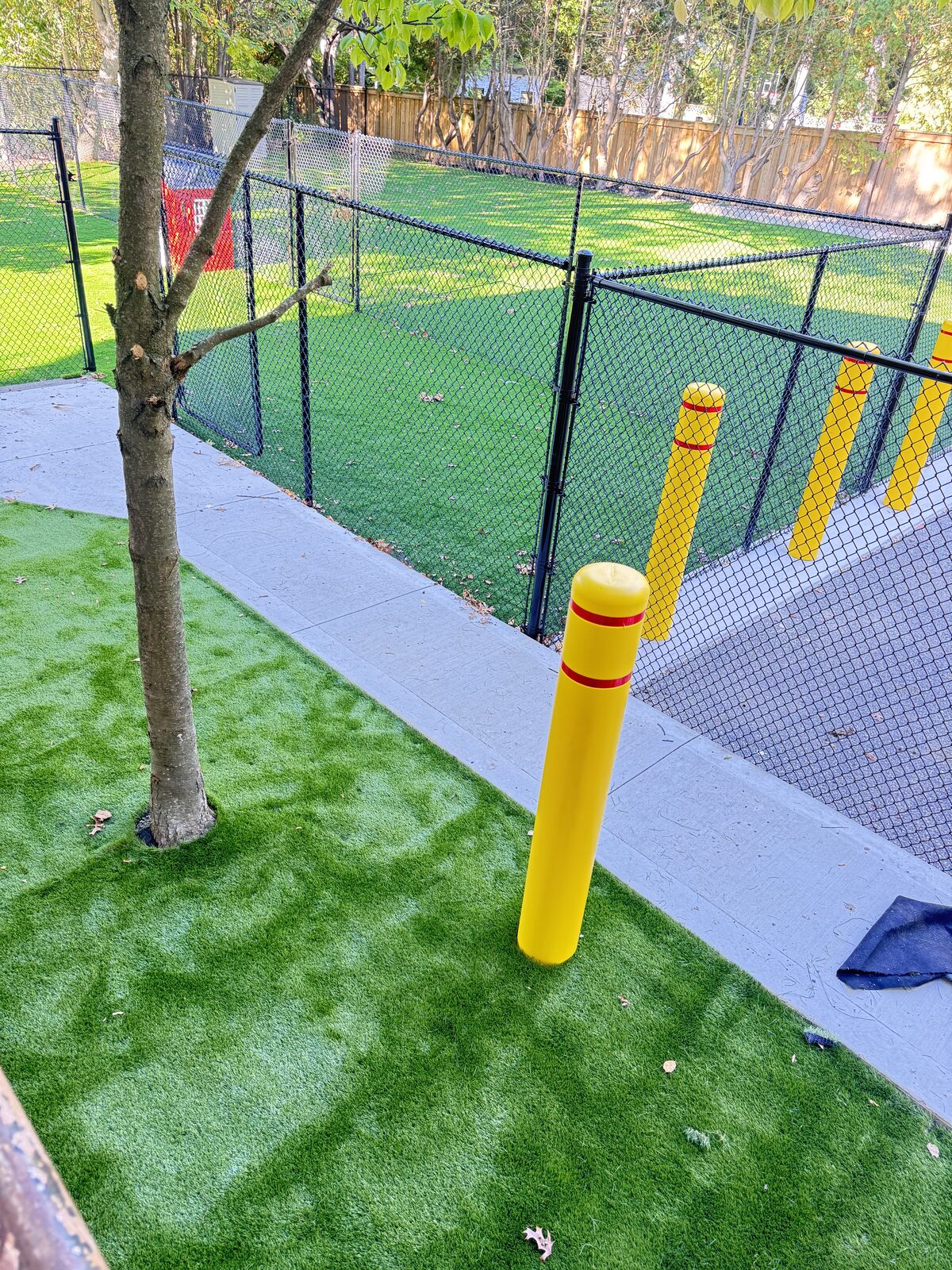 Concrete walkway with artificial turf and bollards for safety