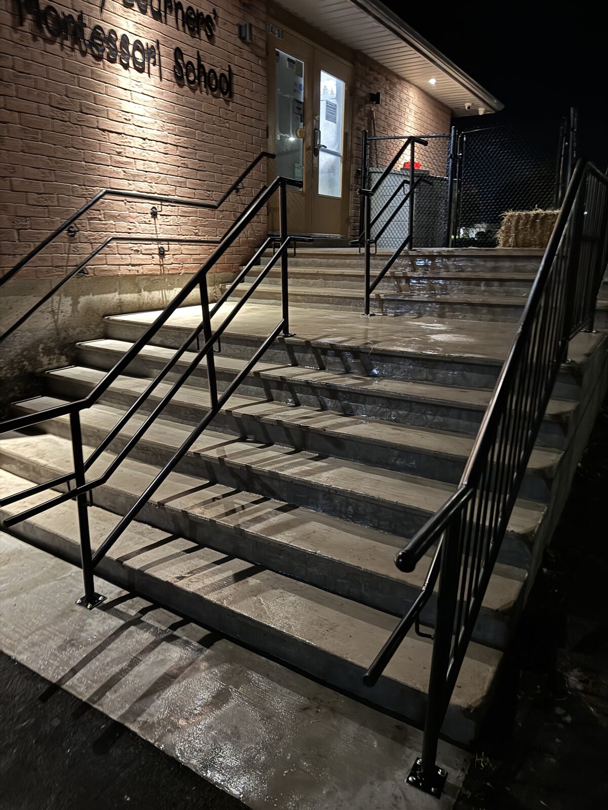 Concrete steps with handrails at a Montessori school at night