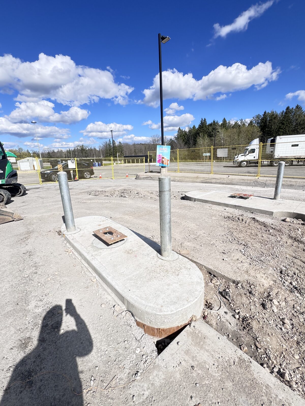 New concrete construction with bollards and light pole base.