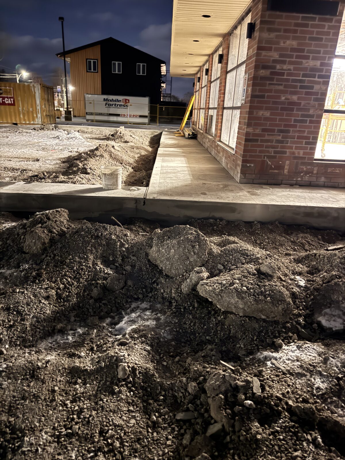 Concrete foundation work for a new commercial building at night.